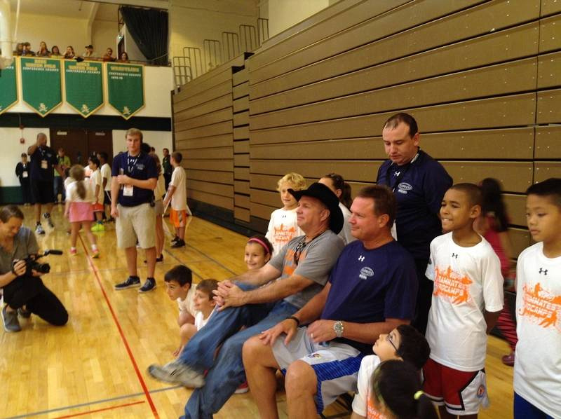 Buddies from their college days together, country music superstar Garth Brooks, in his trademark black hat, and University of Kansas head basketball coach Bill Self sit for a photo with kids at the ProCamp basketball camp Saturday at Elk Grove High School. The event was sponsored by Brooks